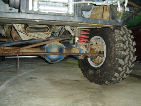 1988 Ford Bronco - Close-up view of the undercarriage of a vehicle, highlighting its suspension and tire components.