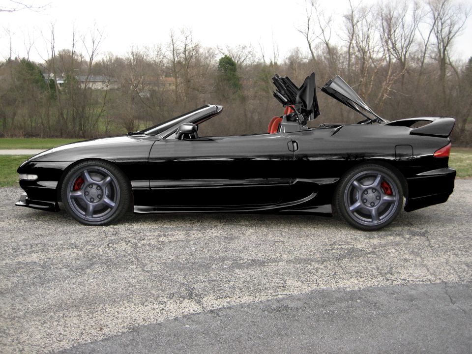 Black 1995 Ford Probe convertible side view with top partially raised