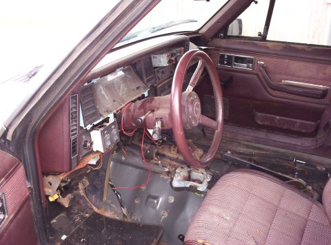 1987 Jeep Cherokee - The interior of a vehicle shows significant disarray with parts of the dashboard removed and wiring exposed.