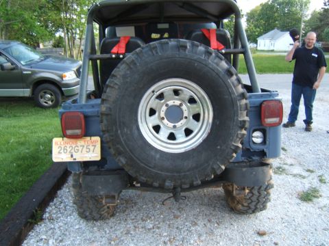 1980 Jeep CJ5 - A dark blue Jeep CJ5 is viewed from the rear, showing its spare tire and a temporary Illinois license plate.