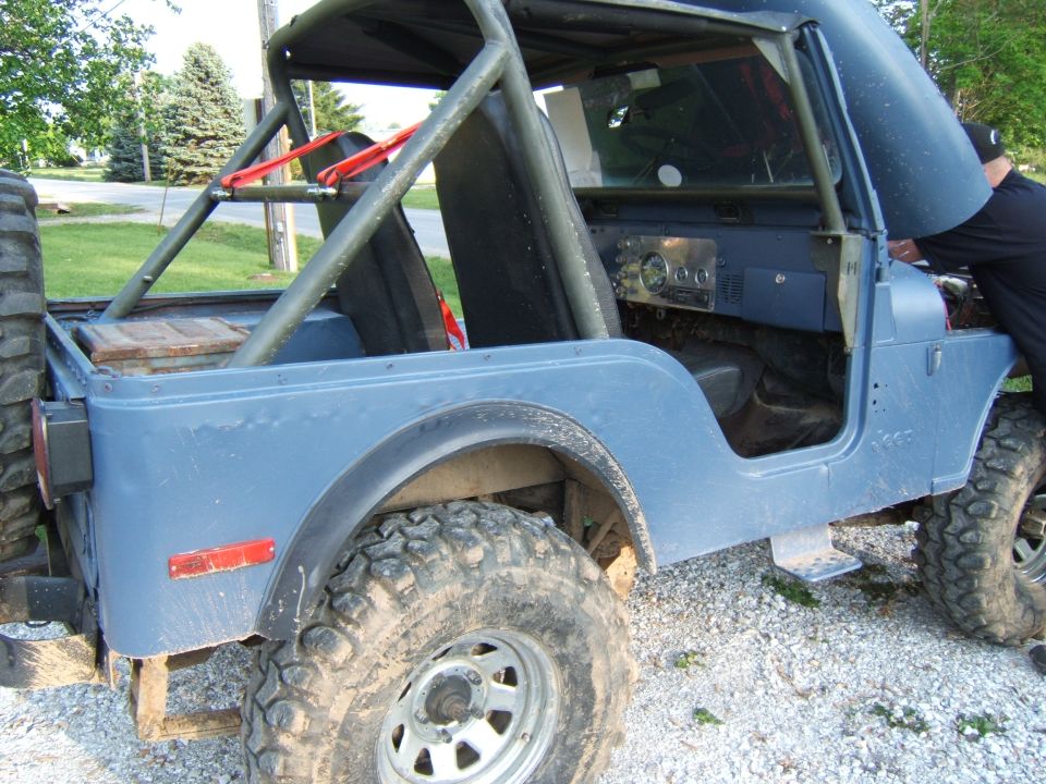 Blue 1980 Jeep CJ5 with roll cage, open hood, and off-road tires