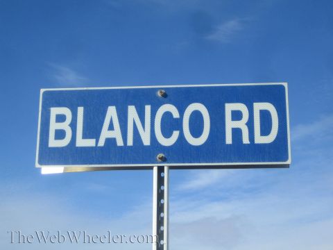 1990 Ford Bronco - blue street sign reading 'BLANCO RD' mounted on a metal post against a bright blue sky.