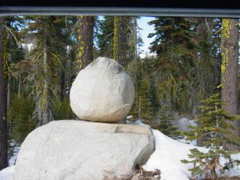 1986 Ford Bronco - Large rocks balanced precariously in a snow-covered forest landscape.