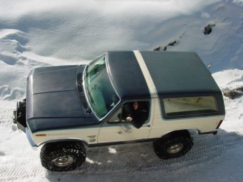 1986 Ford Bronco - Two-tone Ford Bronco navigates a snowy terrain.