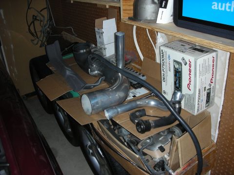 1992 Ford Crown Victoria - Various car parts are stored in boxes and on the floor in a cluttered garage setting.
