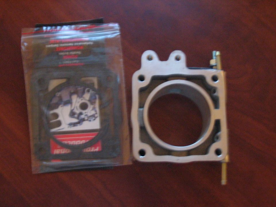 Throttle body and a package of gaskets on a wooden surface