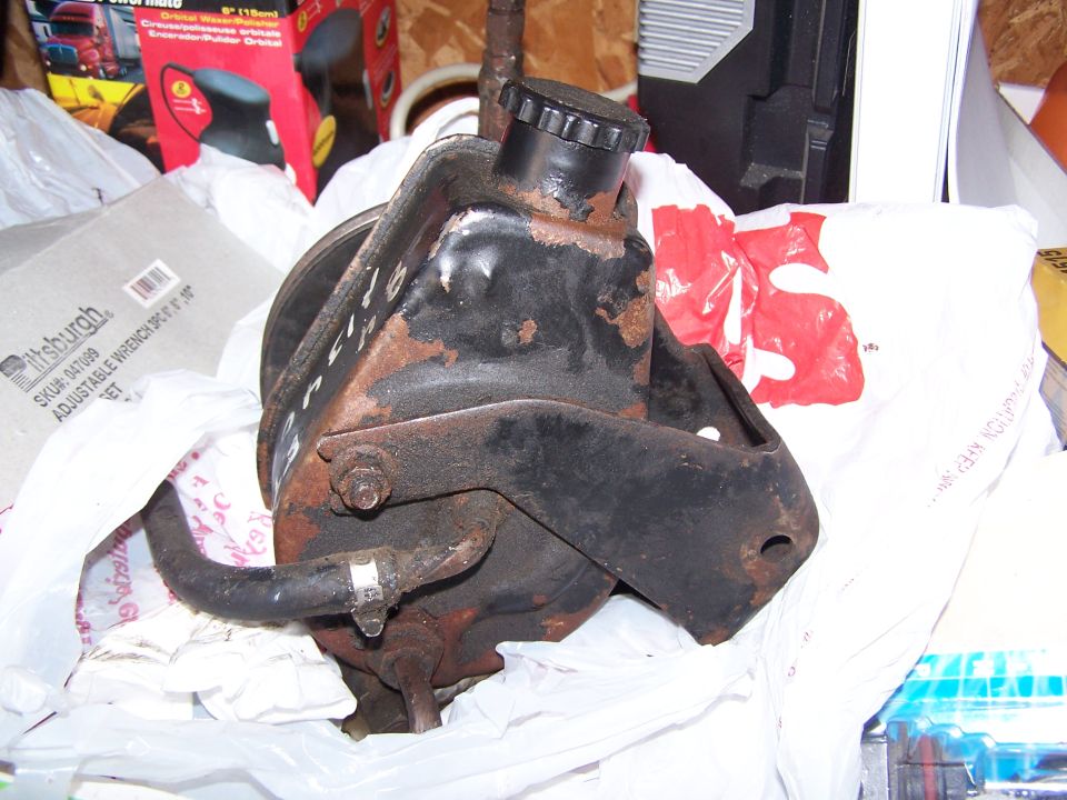 Rusty automotive power steering pump or pulley component on plastic bags