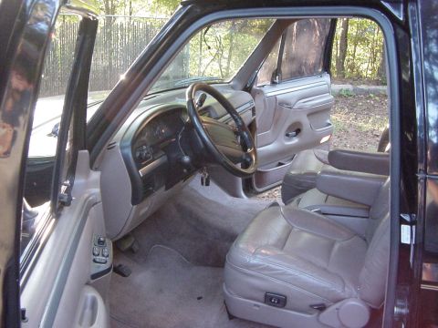 1994 Ford Bronco - The interior of a 1994 Ford Bronco is shown, leather seats and a view of the dashboard.