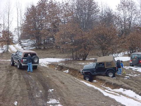 1994 Ford Bronco - A 1994 Ford Bronco navigates a snowy, off-road trail alongside a Jeep and another SUV.