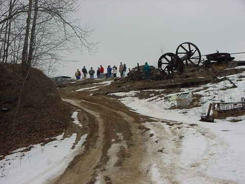 1994 Ford Bronco - A dark SUV is visible on a snowy hill, with several people gathered at the top of the incline.