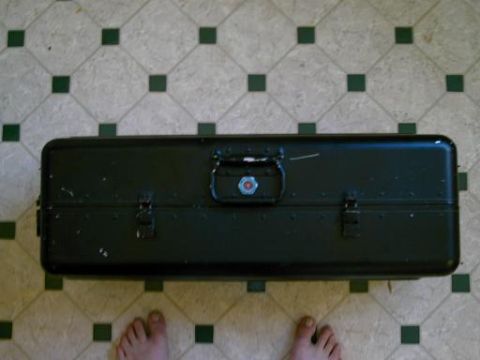 1986 Ford Bronco - A dark green metal toolbox rests on a floor with a diamond tile pattern.