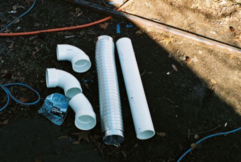 1978 Ford Bronco - Plumbing parts are arranged on the ground, possibly for a custom modification.