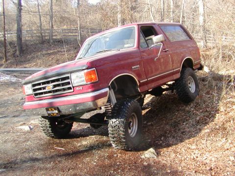 1991 Ford Bronco - This lifted 1991 Ford Bronco navigates a challenging off-road terrain with large tires and a high suspension.