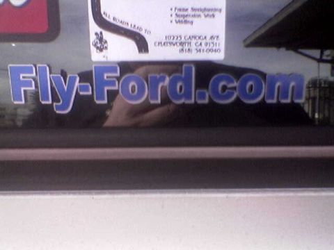 1988 Ford Bronco - Sticker on a window reads "Fly-Ford.com" and shows a reflection.