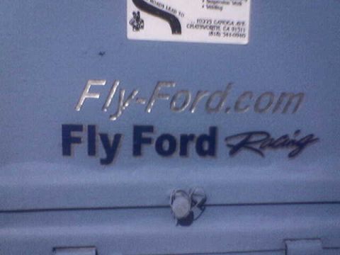 1988 Ford Bronco - A blue surface displays "Fly-Ford.com" and "Fly Ford Racing" text, along with a small document at the top.