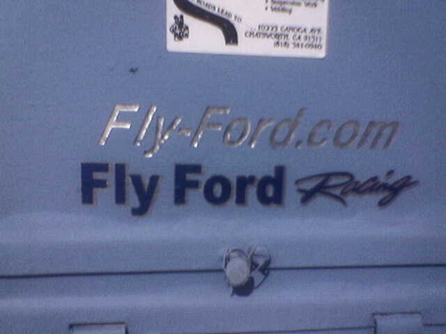 Blue metal surface with "Fly-Ford.com" and "Fly Ford Racing" text
