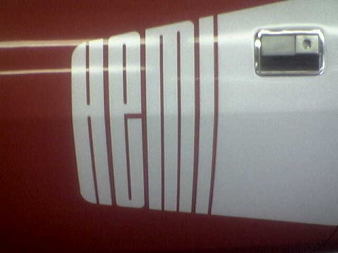 1988 Ford Bronco - Close-up of a side door decal with white lettering on a red and white vehicle.