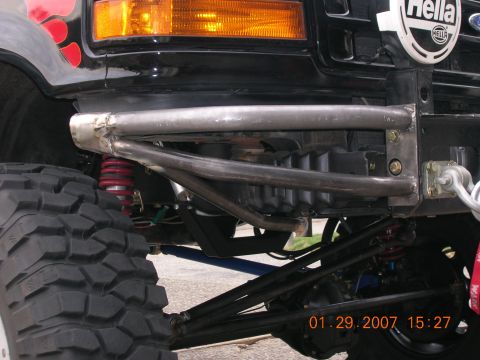1996 Ford Bronco - Close-up view of a vehicle's custom bumper, suspension, and Hella lights, showing off its off-road modifications.