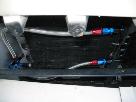 1985 Ford LTD Crown Victoria - Braided oil cooler lines are connected to the vehicle's radiator assembly.