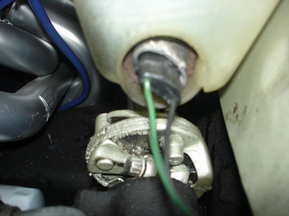 Close-up of a metal engine component with green and black wires connected