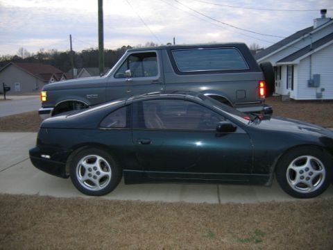 1989 Ford Bronco - A dark green Nissan 300ZX is parked in front of a gray Ford Bronco on a driveway.