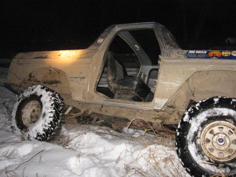 1979 Ford Bronco - This heavily soiled SUV, likely a 1978 model, is stuck in the snow with its doors off.