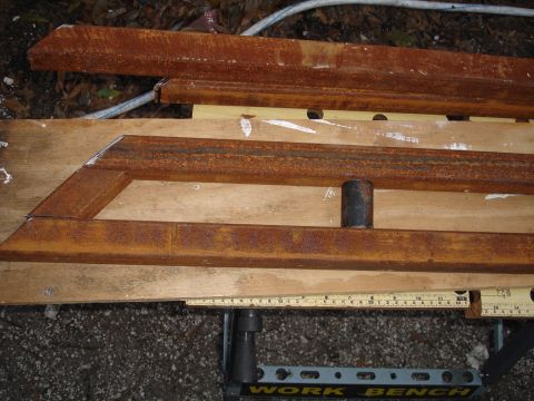 1989 Ford Bronco - These rusty metal sliders are shown on a workbench, with a measuring tape indicating their dimensions.