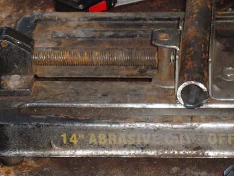 1989 Ford Bronco - A metal pipe is secured in a vise on a 14" abrasive cut-off saw.
