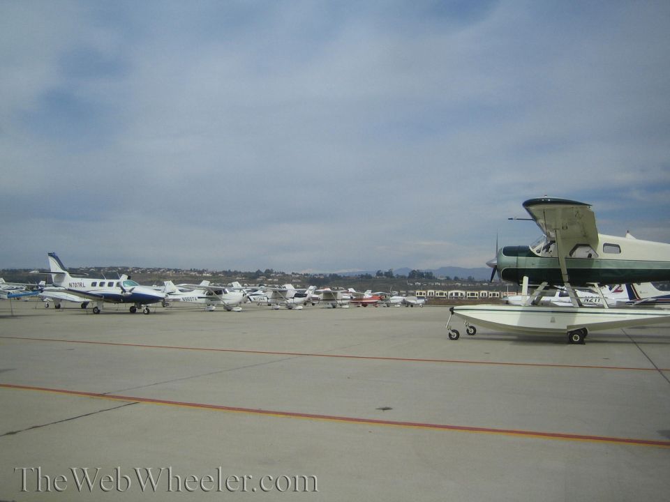 Small aircraft including a floatplane parked on an airport tarmac