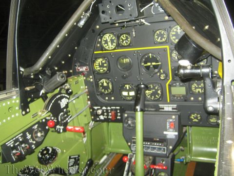 1990 Ford Bronco - cockpit of a vintage aircraft showing a black instrument panel of gauges, the control stick, and throttle quadrant.