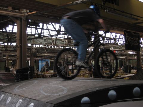 1997 Ford Probe - A person rides a bicycle on a ramp in an indoor skate park.