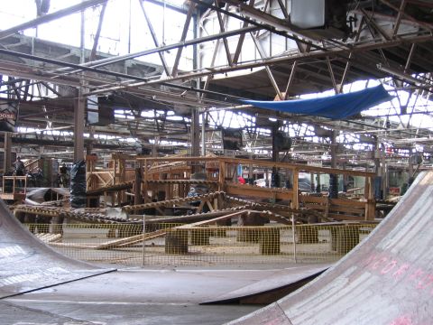 1997 Ford Probe - An indoor skate park features a complex wooden obstacle course with ramps and barriers.