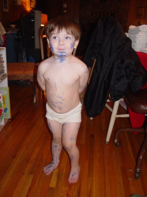 1986 Ford Bronco - A young child stands on a wooden floor, their body covered in blue marker scribbles.