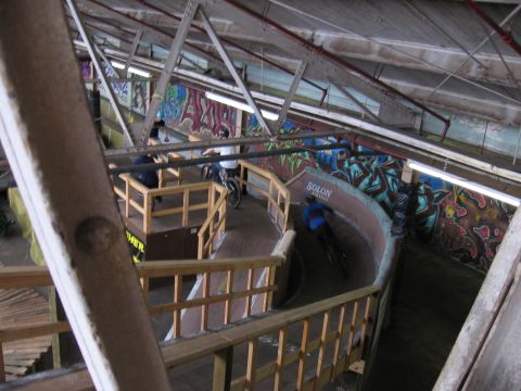 1997 Ford Probe - Graffiti-covered indoor BMX track with riders on the course.