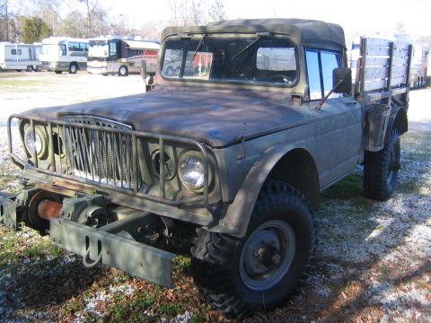 2005 Ford F-250 - Olive drab military truck with a winch and wooden bed sits in a lot with RVs in the background.