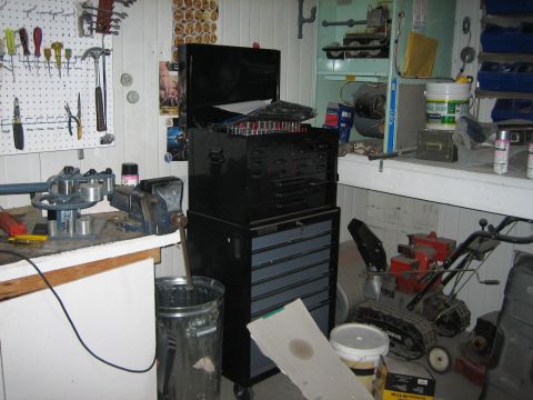 1976 Ford Ranchero - A cluttered garage scene shows a workbench with a vise and tools, a large black toolbox, and a snowblower.