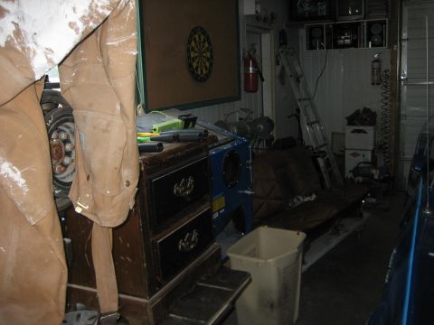 1976 Ford Ranchero - Interior view of a cluttered garage with tools, a dartboard, and a ladder visible.