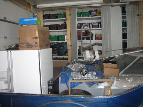 1976 Ford Ranchero - A blue pickup truck bed is visible, with a carburetor and other items on a makeshift table.