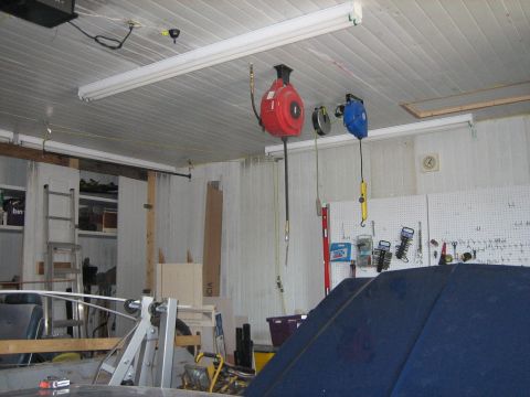 1976 Ford Ranchero - Interior view of a garage with various tools and equipment, including a large blue car cover.