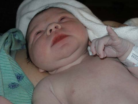 1993 Ford Bronco - A newborn baby is swaddled in a blanket, wearing a hospital identification bracelet.