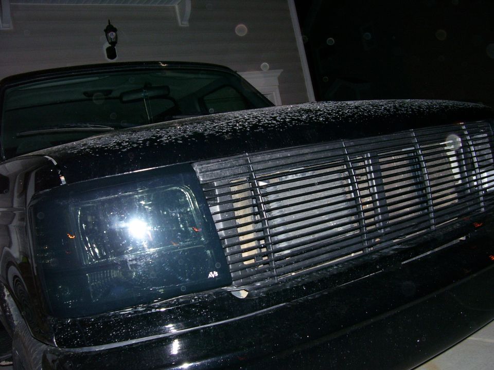 Black Ford Bronco front end with aftermarket grille and smoked headlights. Hood has some white residue