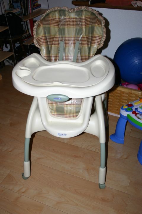 2003 Jeep TJ - This is a Graco baby high chair with a plaid seat and tray, shown indoors.