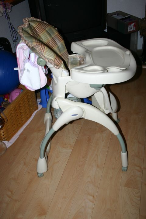 2003 Jeep TJ - A baby high chair is shown in a room with wooden floors and other items in the background.