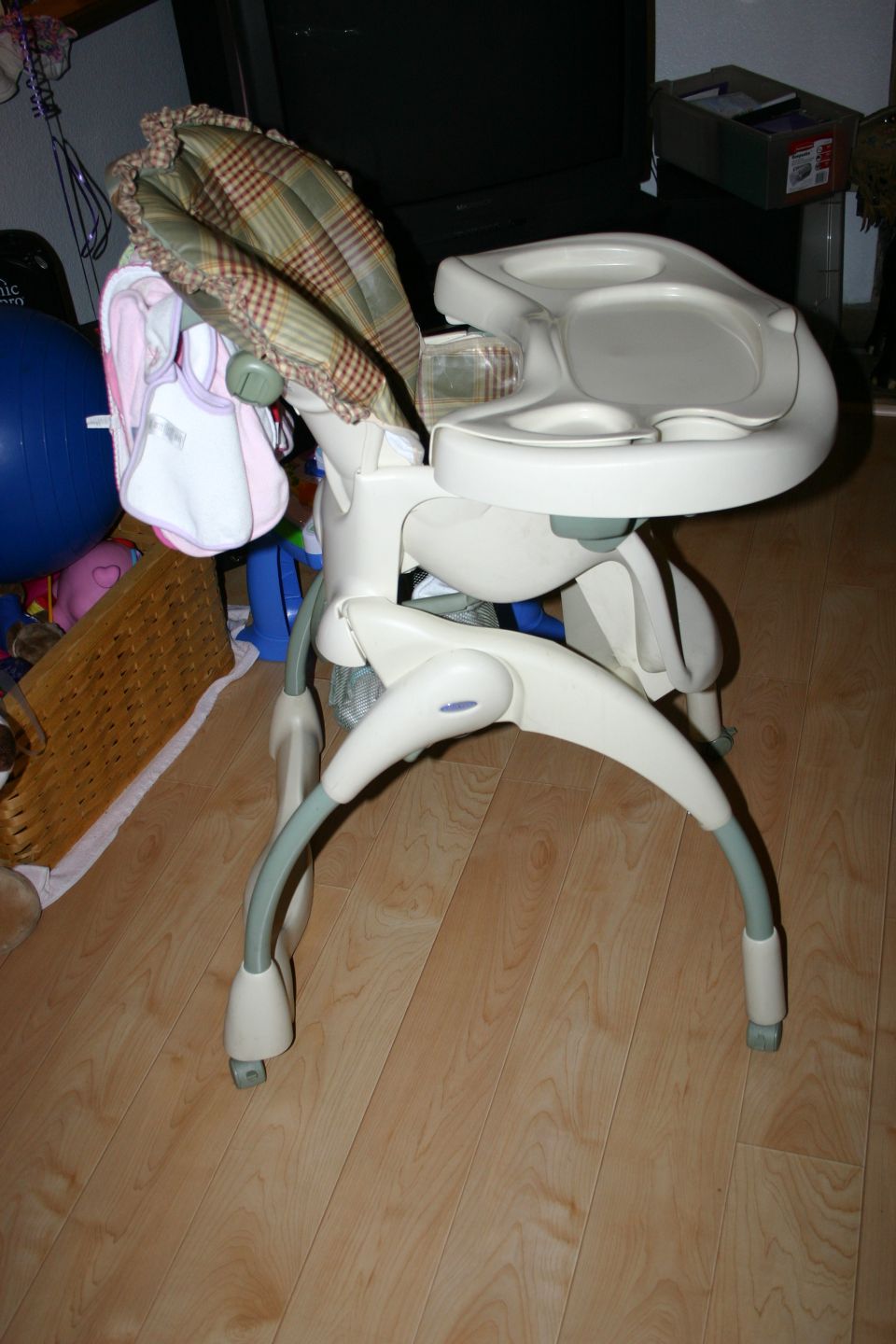 Baby high chair with plaid padding and a tray