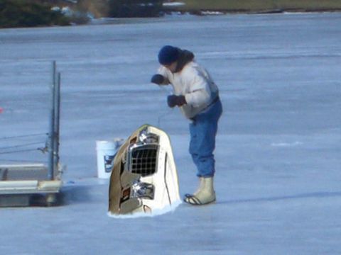 1971 Ford Ranchero - A person ice fishing with a vehicle's front end as part of the scene.