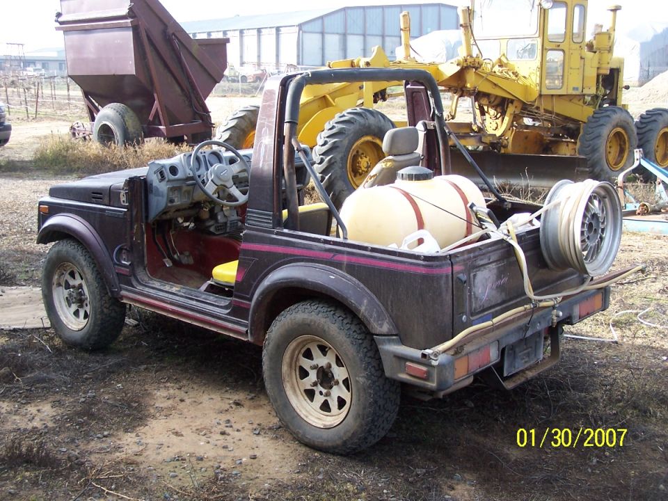 Dark purple open-top 4x4 vehicle with yellow water tank and spare tire on rear.