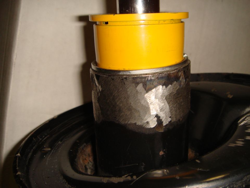 Close-up of a yellow cap on a metallic component, possibly part of a vehicle's suspension or engine