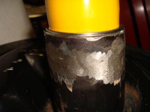 1993 Ford Taurus - A close-up view of a yellow cap atop a metal cylinder, with visible wear on the metal base.