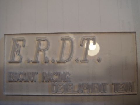 1989 Ford Escort - A sign for ERDT Escort Racing Development Team is shown, with a Supermotors logo at the bottom.