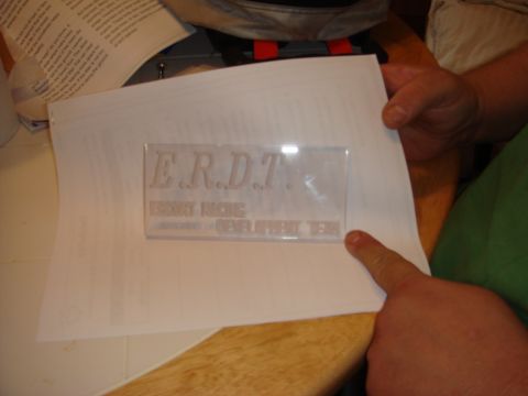 1989 Ford Escort - A document with embossed text is shown, with a finger pointing to it.